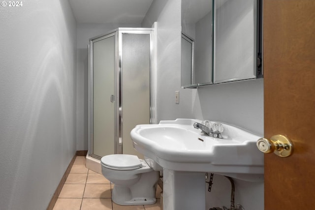 bathroom featuring tile patterned flooring, toilet, and an enclosed shower