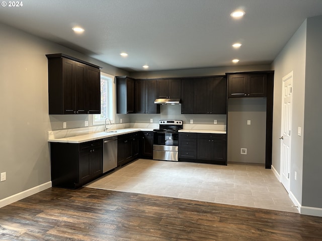 11804 SE Schiller St, Portland, OR 97266 - kitchen featuring appliances with stainless steel finishes, a sink, under cabinet range hood, recessed lighting, and light countertops