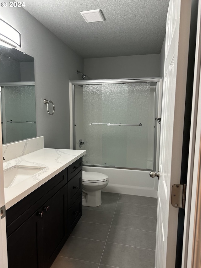 11804 SE Schiller St, Portland, OR 97266 - bathroom with a textured ceiling, tile patterned floors, vanity, enclosed tub / shower combo, and toilet