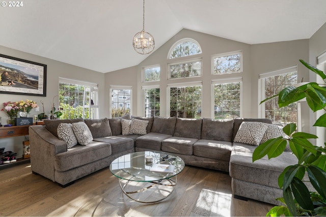 living room featuring high vaulted ceiling, an inviting chandelier, and hardwood / wood-style floors