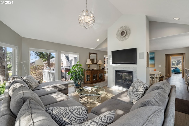 living area featuring a fireplace, light wood-type flooring, a wealth of natural light, and high vaulted ceiling