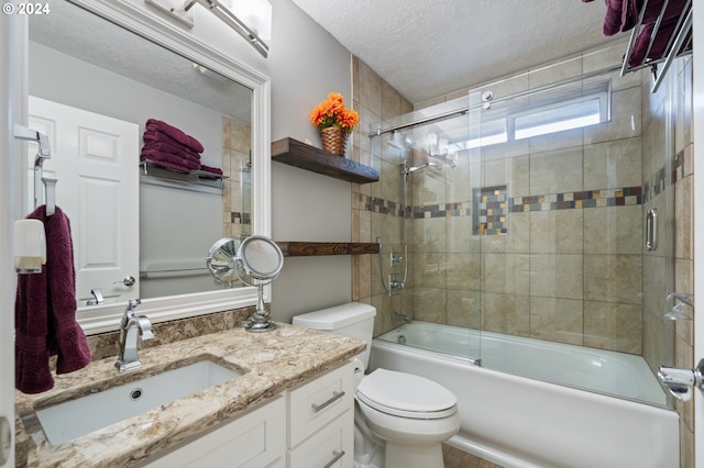 full bathroom featuring vanity, a textured ceiling, shower / bath combination with glass door, and toilet