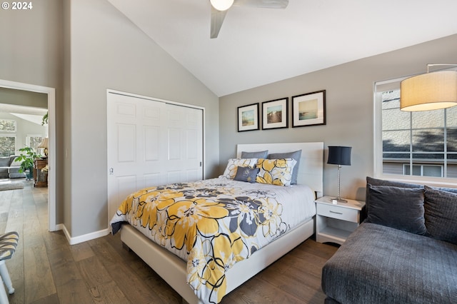 bedroom featuring a ceiling fan, dark wood-style floors, baseboards, vaulted ceiling, and a closet