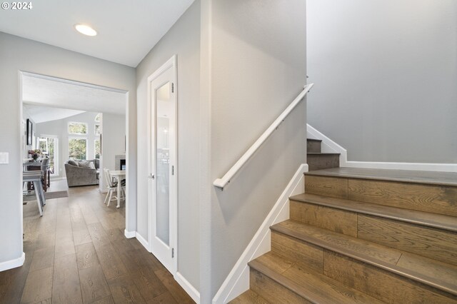 stairs featuring recessed lighting, baseboards, lofted ceiling, and hardwood / wood-style floors