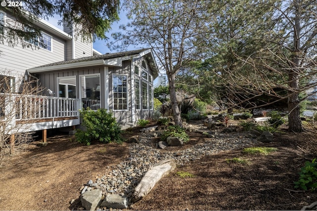 view of property exterior with board and batten siding and a deck