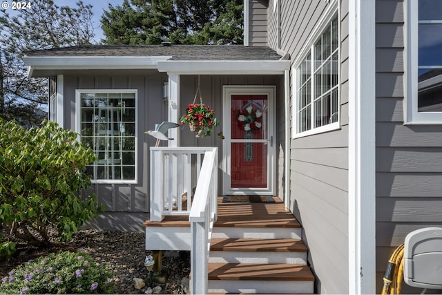 entrance to property with roof with shingles and board and batten siding