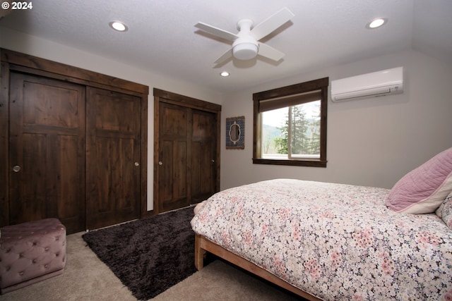 bedroom featuring an AC wall unit, two closets, light colored carpet, ceiling fan, and lofted ceiling