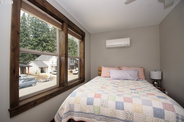 bedroom featuring ceiling fan and a wall unit AC