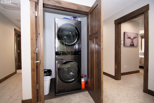 laundry room featuring light colored carpet and stacked washer and dryer