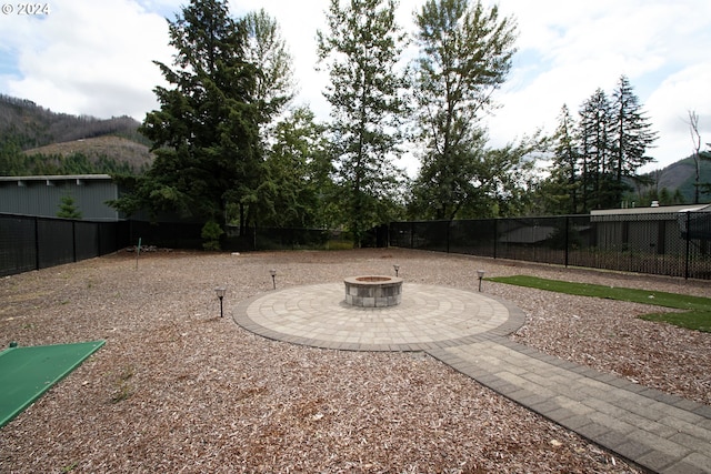 view of yard with a mountain view, an outdoor fire pit, and a patio area