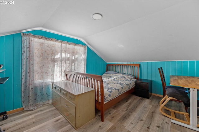 bedroom featuring light hardwood / wood-style floors and vaulted ceiling