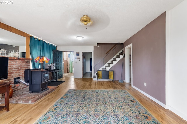 entrance foyer with a textured ceiling, a wood stove, and hardwood / wood-style flooring