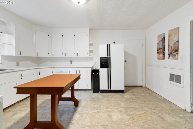 kitchen featuring white fridge with ice dispenser, a textured ceiling, sink, and white cabinetry