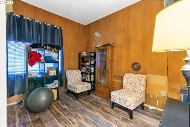 sitting room featuring wooden walls and dark hardwood / wood-style flooring