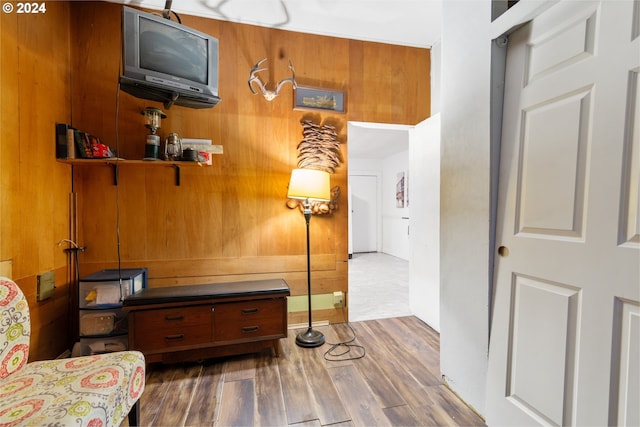 living area featuring wood-type flooring and wood walls