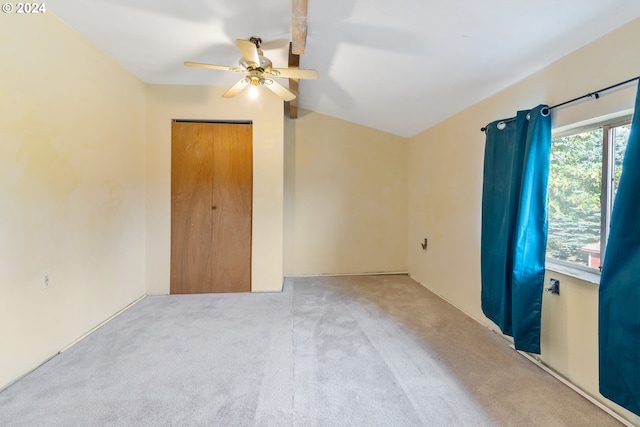 unfurnished bedroom featuring lofted ceiling, light carpet, ceiling fan, and a closet