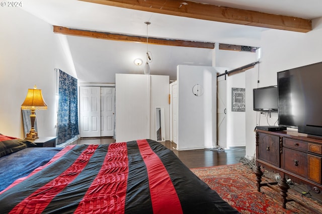 bedroom with a closet, beamed ceiling, dark hardwood / wood-style floors, and a barn door