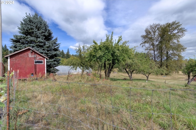 view of yard featuring a storage shed and a rural view