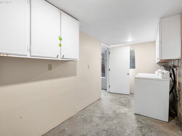 clothes washing area featuring cabinets and independent washer and dryer