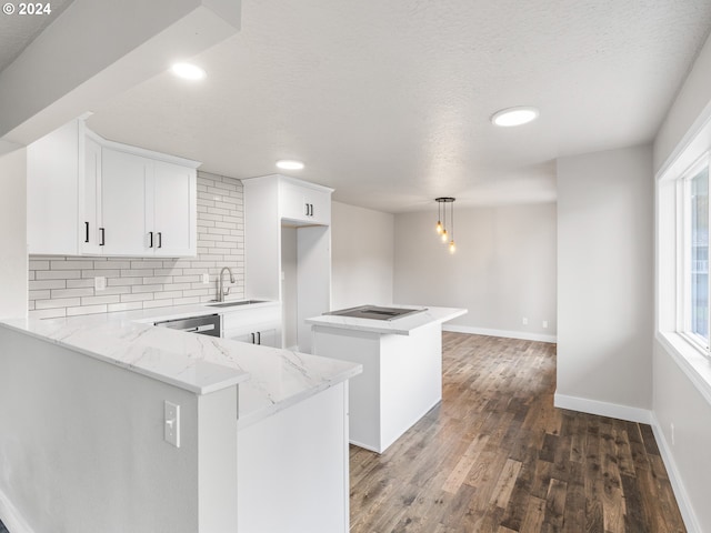 kitchen featuring sink, dark wood-type flooring, kitchen peninsula, pendant lighting, and white cabinets