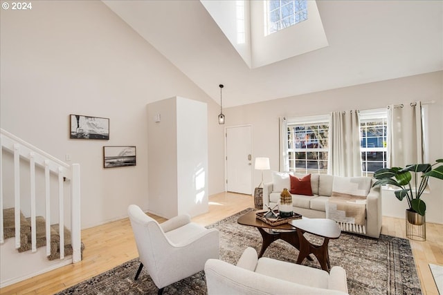 living room featuring light wood-type flooring and high vaulted ceiling