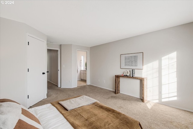 unfurnished bedroom with ensuite bathroom and light colored carpet