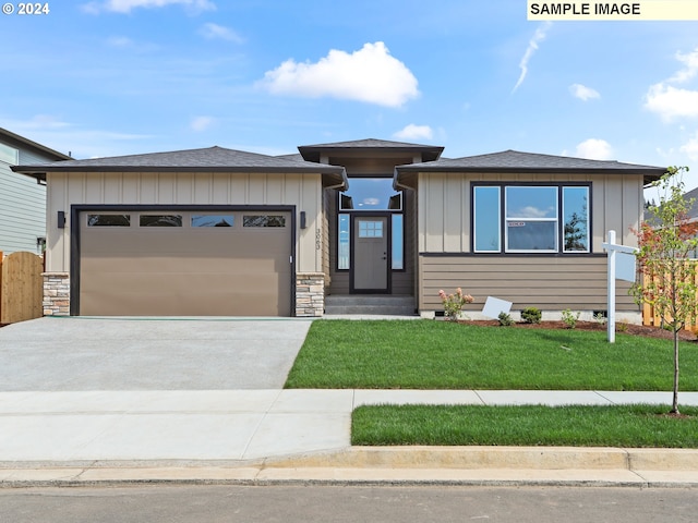 view of front of property featuring a garage and a front lawn