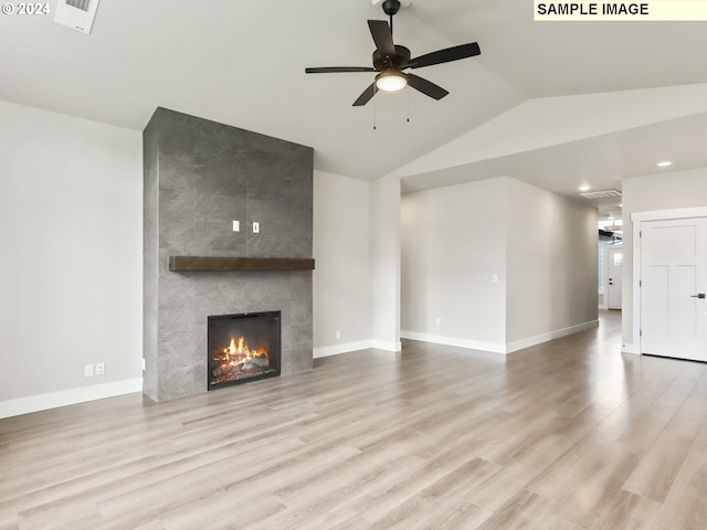 unfurnished living room with a fireplace, light hardwood / wood-style flooring, ceiling fan, and lofted ceiling