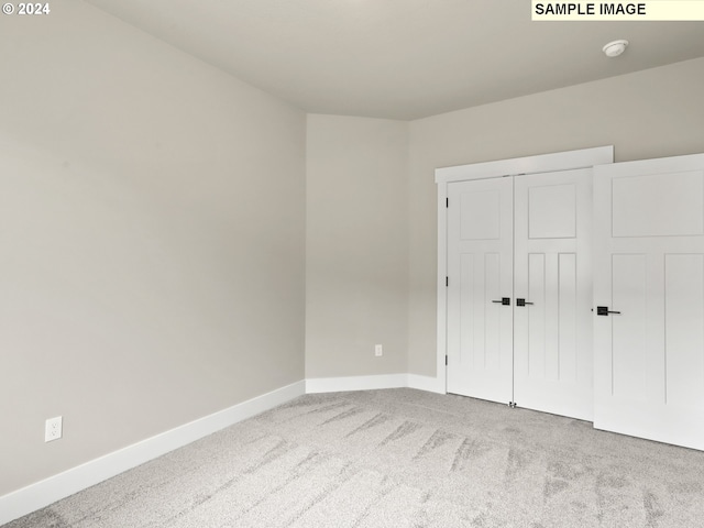 unfurnished bedroom featuring carpet flooring and a closet