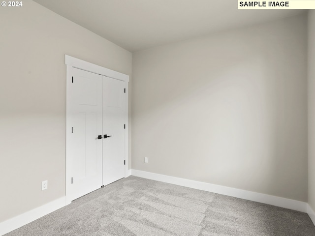 unfurnished bedroom with carpet floors and a closet