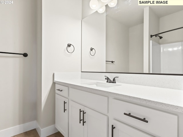 bathroom featuring a shower and vanity