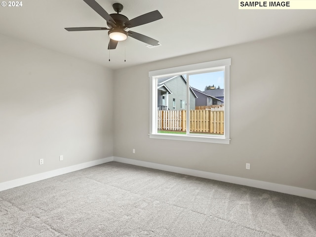 carpeted spare room with ceiling fan