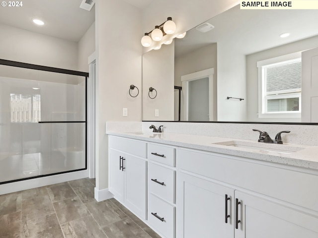 bathroom featuring vanity and a shower with shower door