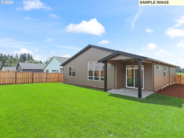 rear view of house featuring a yard and a patio