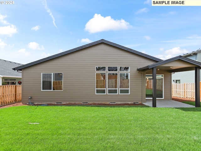 rear view of house with a yard and a patio