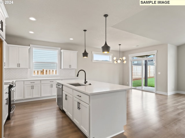 kitchen with hanging light fixtures, sink, an island with sink, and a wealth of natural light