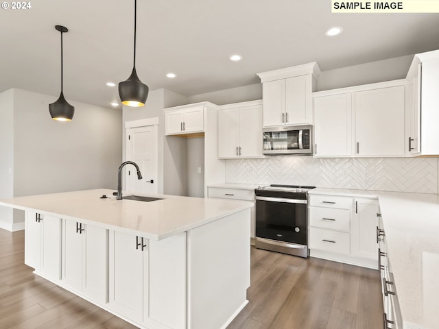 kitchen featuring stainless steel appliances, pendant lighting, a center island with sink, white cabinets, and dark hardwood / wood-style floors