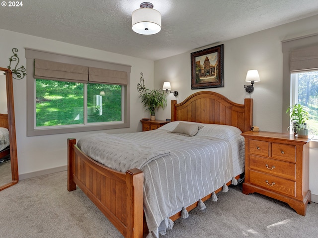 bedroom featuring light carpet and a textured ceiling