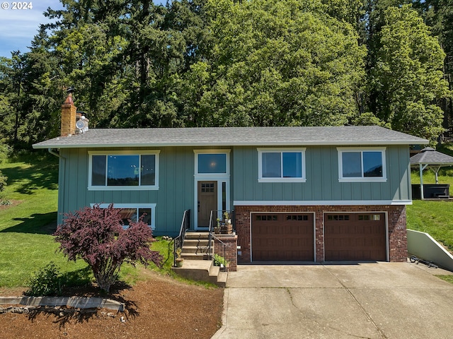 split foyer home with a garage and a front lawn