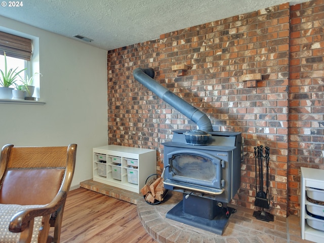 interior details featuring hardwood / wood-style floors, a wood stove, and a textured ceiling