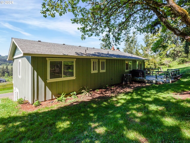 rear view of property featuring a lawn and a wooden deck