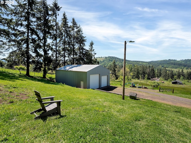 view of yard featuring a mountain view, an outdoor structure, and a garage