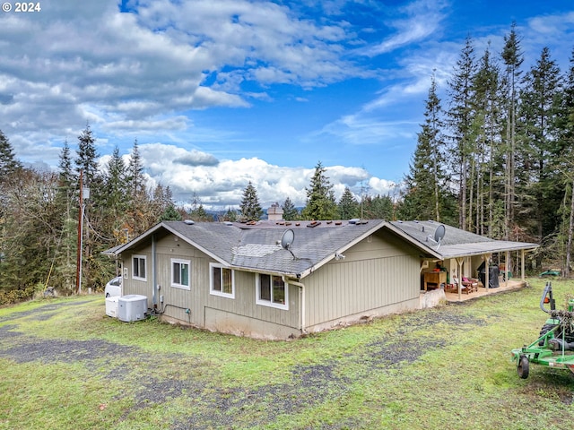 view of property exterior featuring a lawn and a patio area