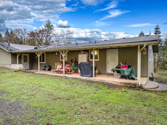 back of house with a lawn and a patio