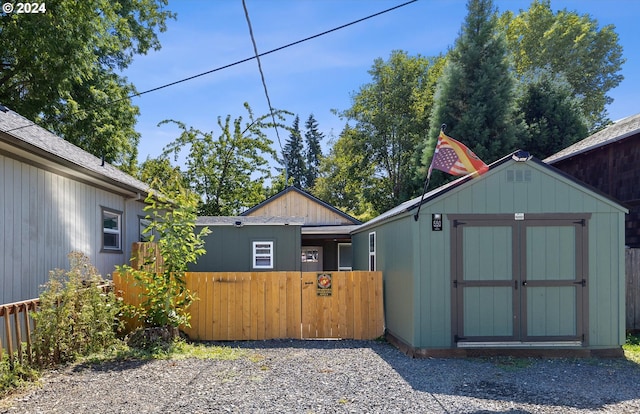 exterior space with an outbuilding, fence, and a storage shed