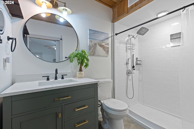 full bathroom featuring vanity, a tile shower, and toilet