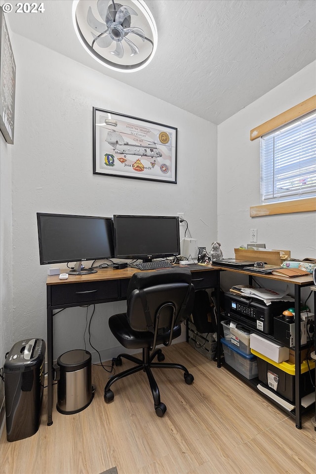 home office featuring lofted ceiling, a textured ceiling, and wood finished floors