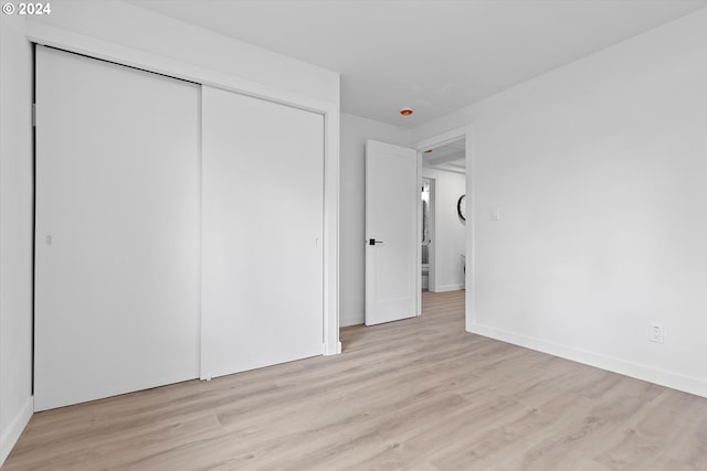 unfurnished bedroom with light hardwood / wood-style floors and a closet