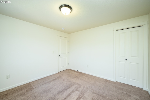 unfurnished bedroom with carpet flooring and a closet