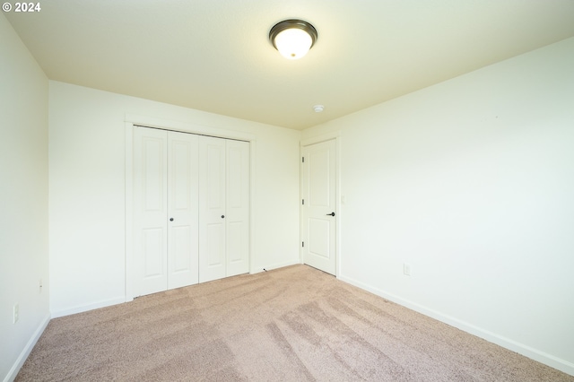 unfurnished bedroom with a closet and carpet flooring